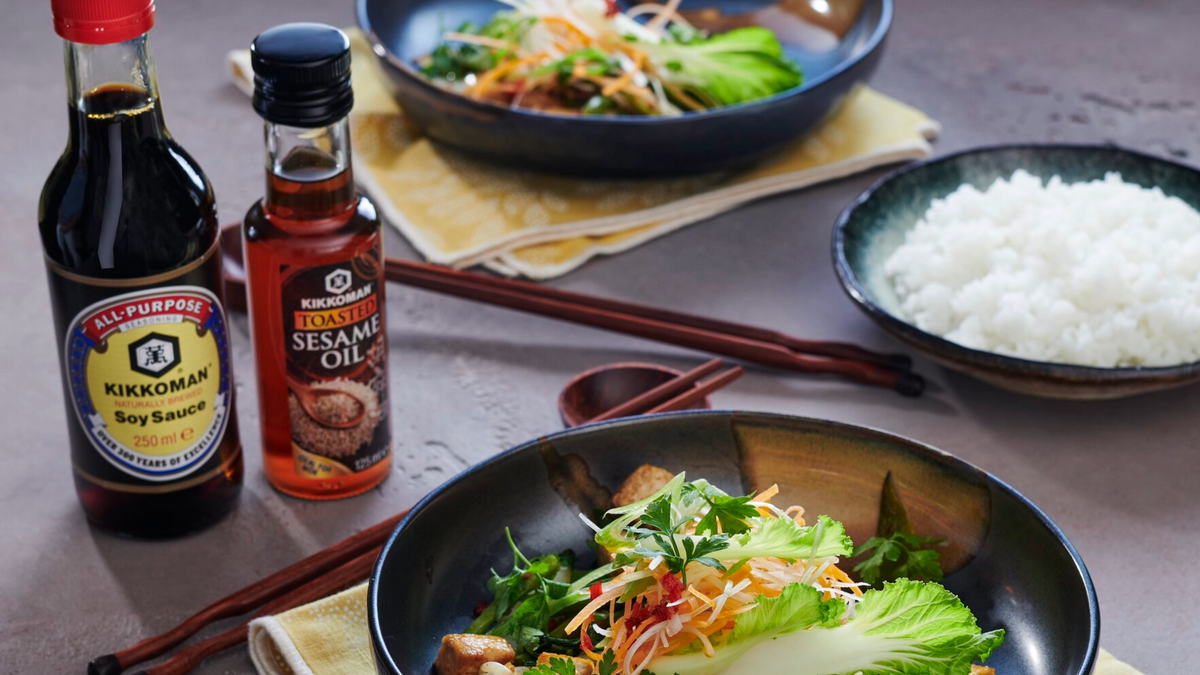 Öljyt: Kikkoman Sesame Oil ja soijakastike sekä ruoka-annokset pöydällä